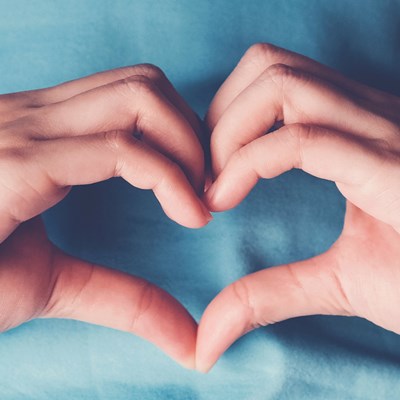 Wellbeing represented by hands in a heart shape